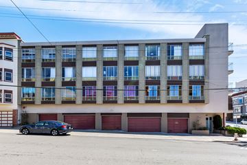 San Francisco apartment for rent - A car is parked in front of a building with a red garage door.
