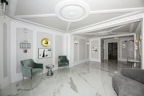 San Francisco apartment for rent - A white hallway with a green chair and a grey couch.