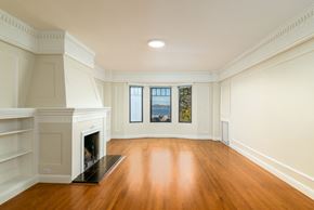 San Francisco apartment for rent - A large empty room with a fireplace and wood flooring.