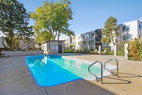 Aurora apartment for rent - our apartments have a swimming pool with an apartment building in the background at Park at Fitzsimons Apartments, Aurora