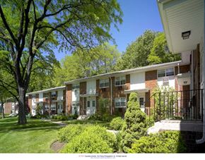 Paterson apartment for rent - a row of apartments with a lawn and trees