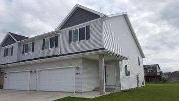 West Fargo apartment for rent - A two-story house with a garage on the ground floor.