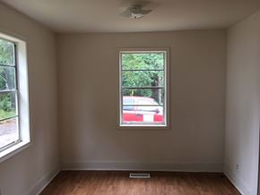 Talladega house for rent - an empty room with a window and a red car in it