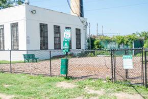 Upper Darby apartment for rent - an old building with a green bench behind a chain link fence