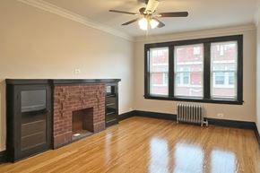 Oak Park apartment for rent - A living room with a fireplace and a ceiling fan.
