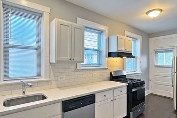 Oak Park apartment for rent - A kitchen with white cabinets and a black stove top oven.