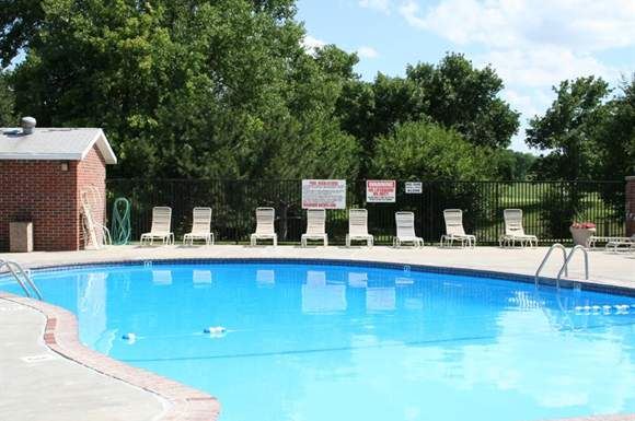 Omaha apartment for rent - a large swimming pool with chairs around it