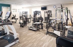 Omaha apartment for rent - a gym with cardio equipment and weights on the floor
