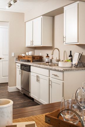 Omaha apartment for rent - a kitchen with white cabinets and a counter top and a sink