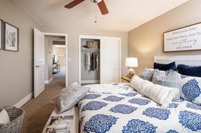 Omaha apartment for rent - a bedroom with a blue and white bed and a ceiling fan