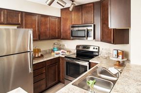 Omaha apartment for rent - a kitchen with stainless steel appliances and wooden cabinets