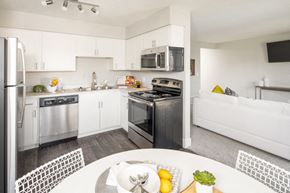 Omaha apartment for rent - a white kitchen with stainless steel appliances and a white table