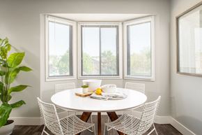 Omaha apartment for rent - a dining room with a white table and chairs and three windows