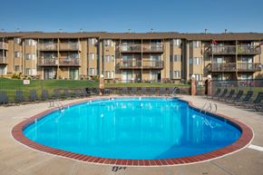 Omaha apartment for rent - a large blue swimming pool in front of an apartment building
