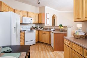 Omaha apartment for rent - a kitchen with white appliances and wooden cabinets