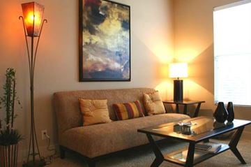 Council Bluffs apartment for rent - A living room with a couch, a table, and a painting on the wall.