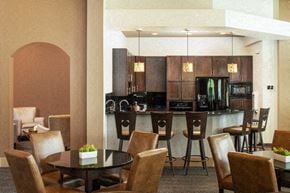 Omaha apartment for rent - A modern kitchen with brown chairs and a black table.