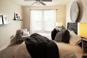 Omaha apartment for rent - A bedroom with a large bed and a ceiling fan.