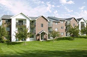 Omaha apartment for rent - an apartment building with green grass and trees