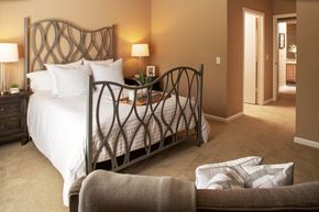 Omaha apartment for rent - A bedroom with a large bed and a chair.