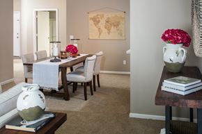 Omaha apartment for rent - a dining room with a table and chairs and a vase with flowers