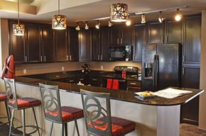 Bellevue apartment for rent - A kitchen with dark wood cabinets and a black refrigerator.