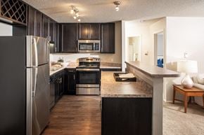 Lincoln apartment for rent - a kitchen with stainless steel appliances and dark wood cabinets