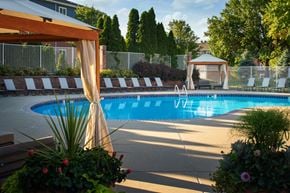 Lincoln apartment for rent - a swimming pool in a backyard with a gazebo and chairs