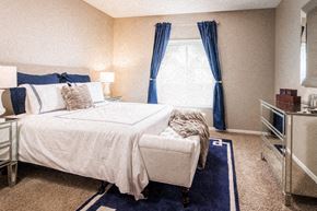 Lincoln apartment for rent - a bedroom with a bed and a window with blue curtains