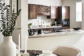West Des Moines apartment for rent - a kitchen with wooden cabinets and a table with a vase
