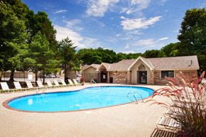 Windsor Heights apartment for rent - a swimming pool with chairs around it in front of a house