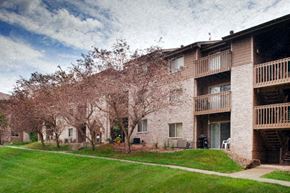 Des Moines apartment for rent - a brick apartment building with a lawn and flowering trees