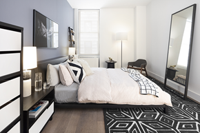 New York apartment for rent - a bedroom with a large bed and a black and white rug