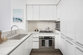 New York apartment for rent - a kitchen with white cabinets and a sink and a stove