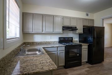Atlanta apartment for rent - an empty kitchen with granite counter tops and black appliances