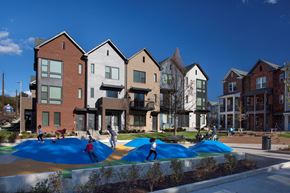 Nashville triplex for rent - A playground with a blue surface is surrounded by a row of houses.