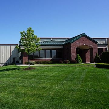 Clifton Park apartment for rent - A red brick building with a green roof and a tree in front.