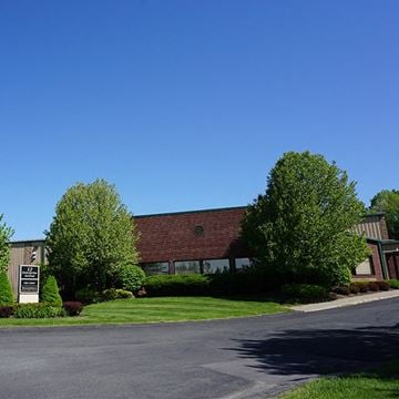 Clifton Park apartment for rent - A building with a red roof and a sign in front of it.