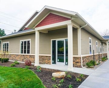 Latham apartment for rent - A small building with a red roof and a stone wall.