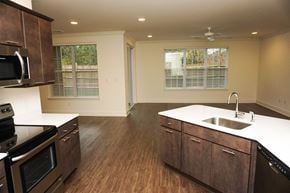 Latham apartment for rent - A kitchen with a black stove top oven and wooden cabinets.