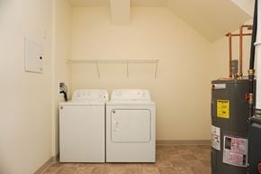 Latham apartment for rent - Two white front loading washing machines in a laundry room.