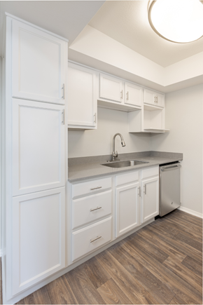 Phoenix apartment for rent - A kitchen with white cabinets and a wooden floor.