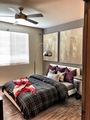 Phoenix apartment for rent - A bedroom with a bed covered in a plaid comforter and pillows.