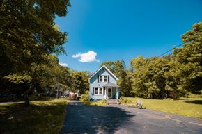 East Haven apartment for rent - a small blue house with a driveway and trees