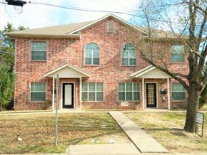 Commerce apartment for rent - a brick house with a sidewalk in front of it