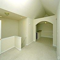Shelby Twp apartment for rent - an empty living room with an arched doorway and white walls