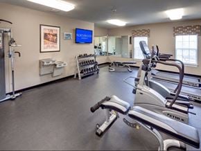 Middletown apartment for rent - a gym with cardio equipment and a tv on the wall