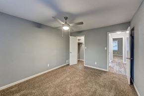 Chamblee apartment for rent - an empty living room with blue walls and a ceiling fan