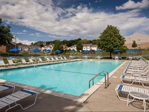 Middletown apartment for rent - a swimming pool with white chairs and blue umbrellas