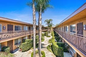 Downey apartment for rent - a courtyard with palm trees and a building with balconies